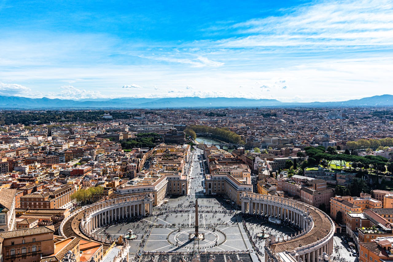 who-we-are A stunning aerial view of St. Peter's Square in Vatican City with clear blue skies.